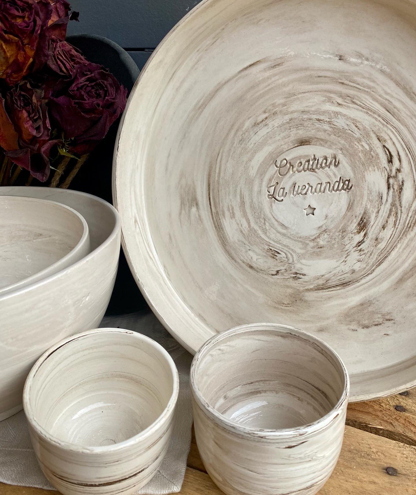 Grand plat en terre mêlée avec signature Création La Véranda gravée, bols et tasses autour