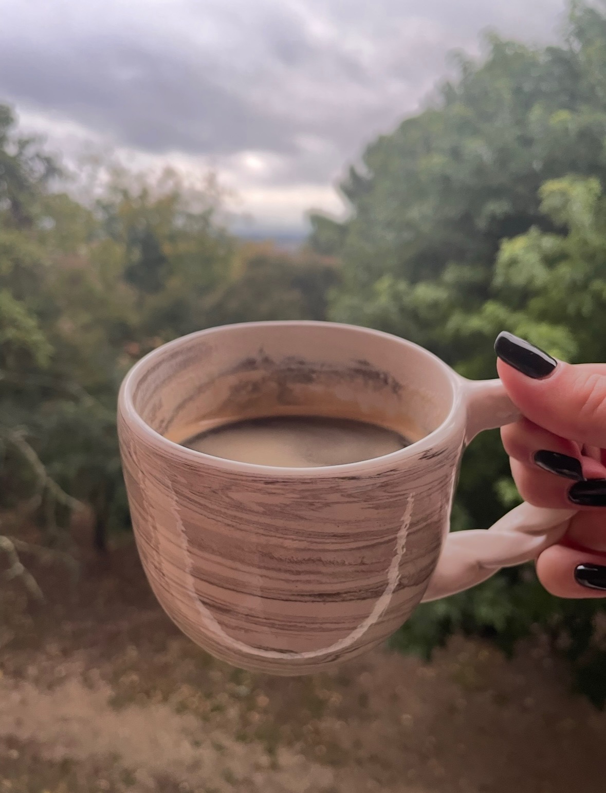 Mug en terre mêlée tenu à la main devant un panorama de campagne provençale, La Véranda Ansouis